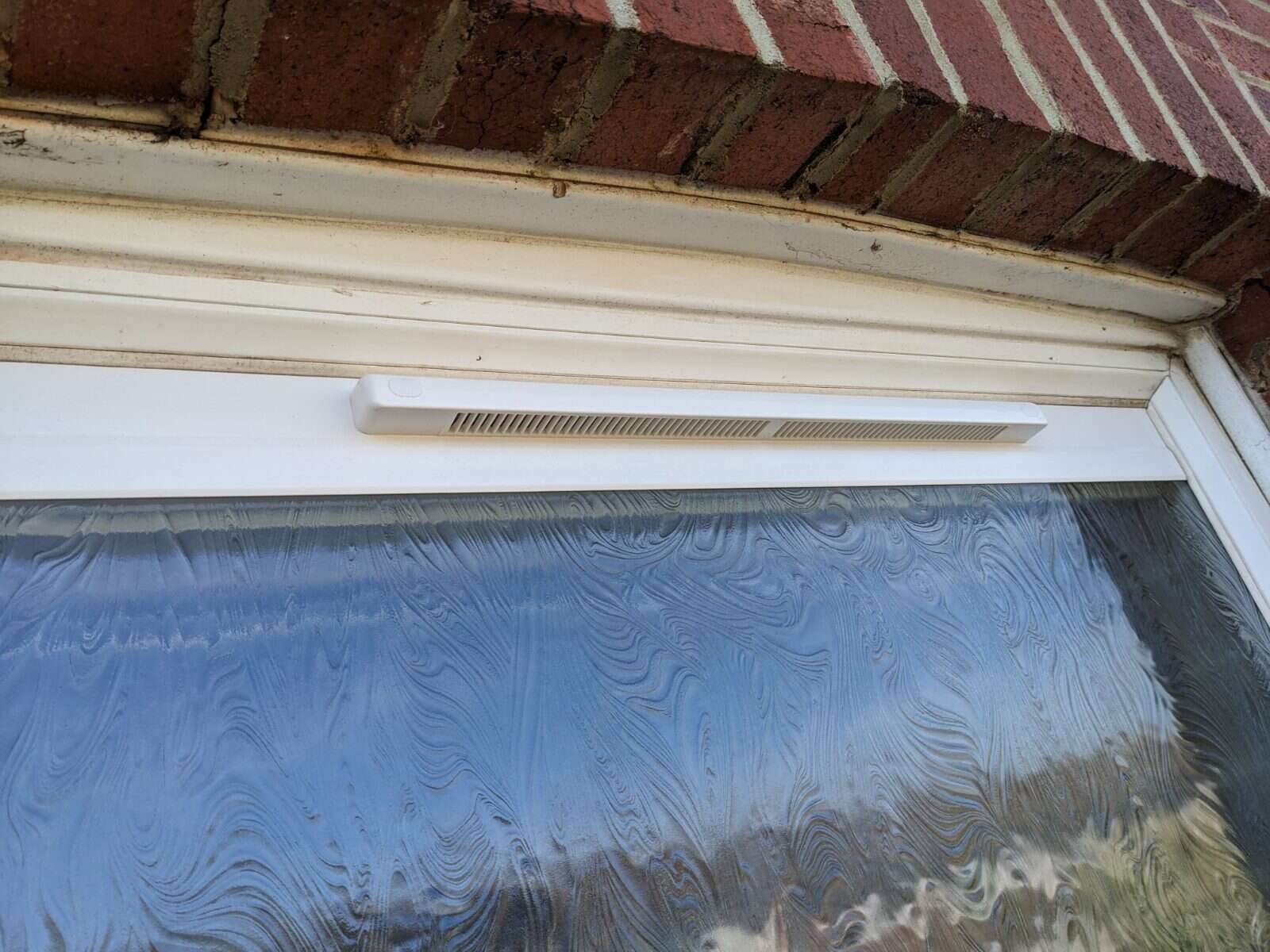 White rendered home with a full set of windows fitted with retrofit Glass Vents